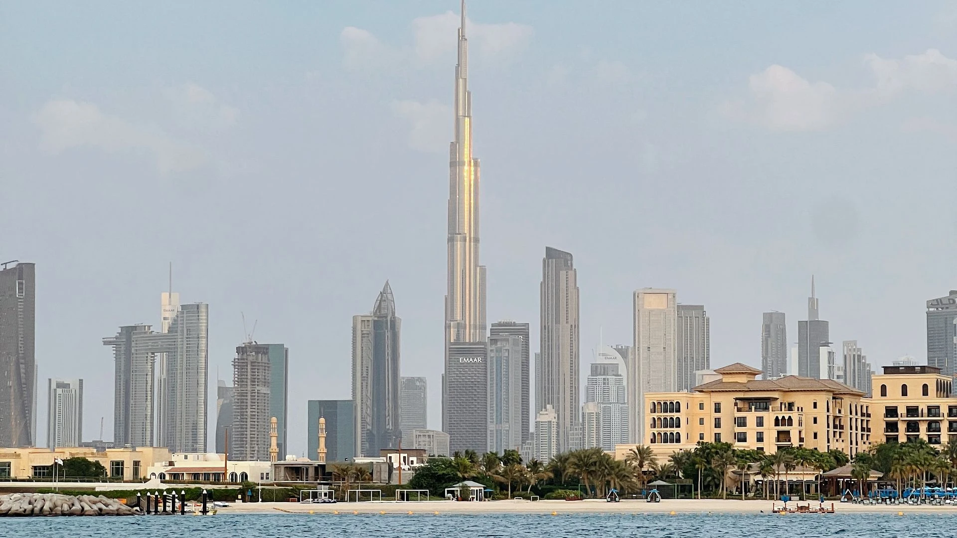 Dubai skyline at sunset with Burj Khalifa and modern skyscrapers reflected in water