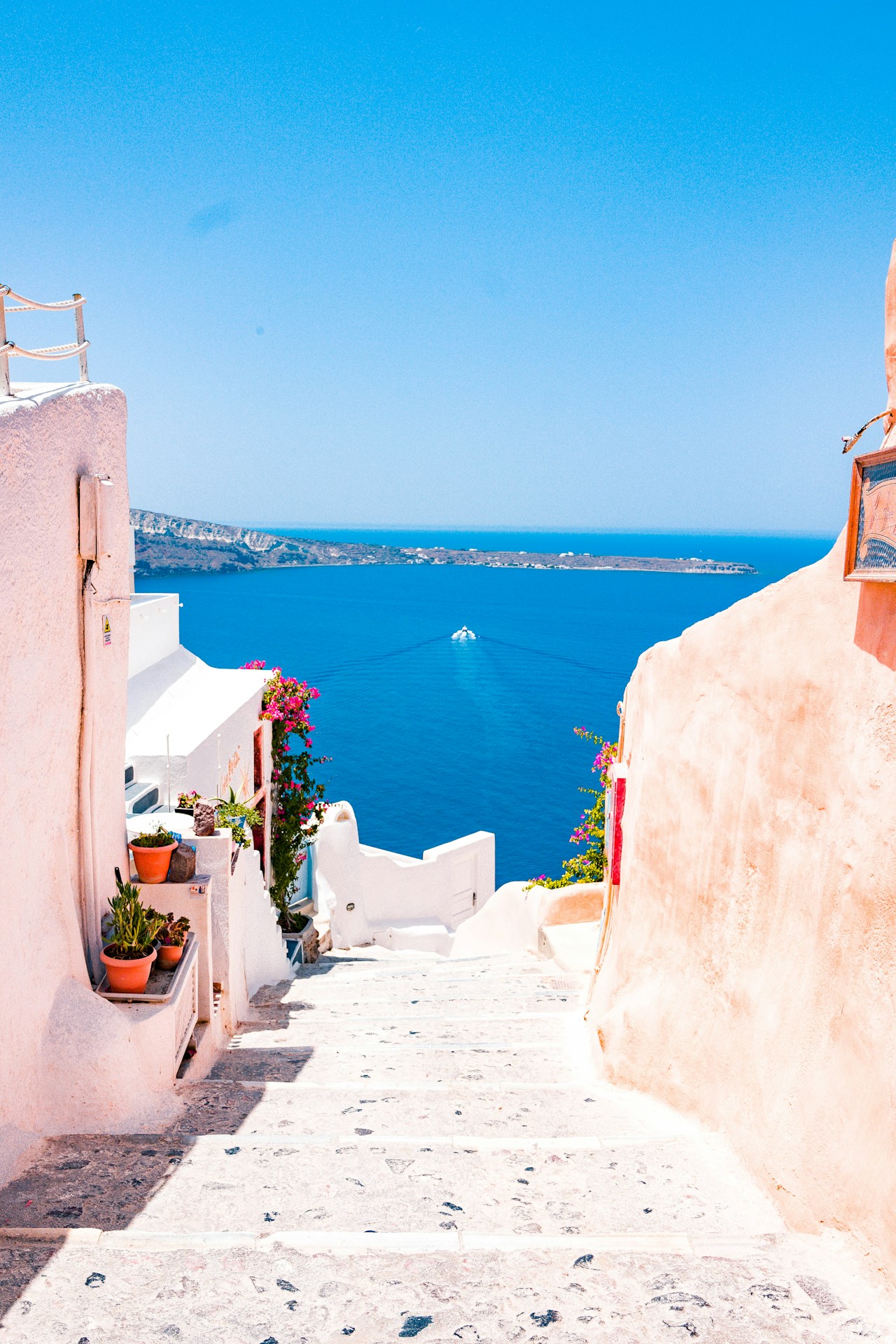 Group of friends laughing on rooftop terrace overlooking Greek island whitewashed buildings
