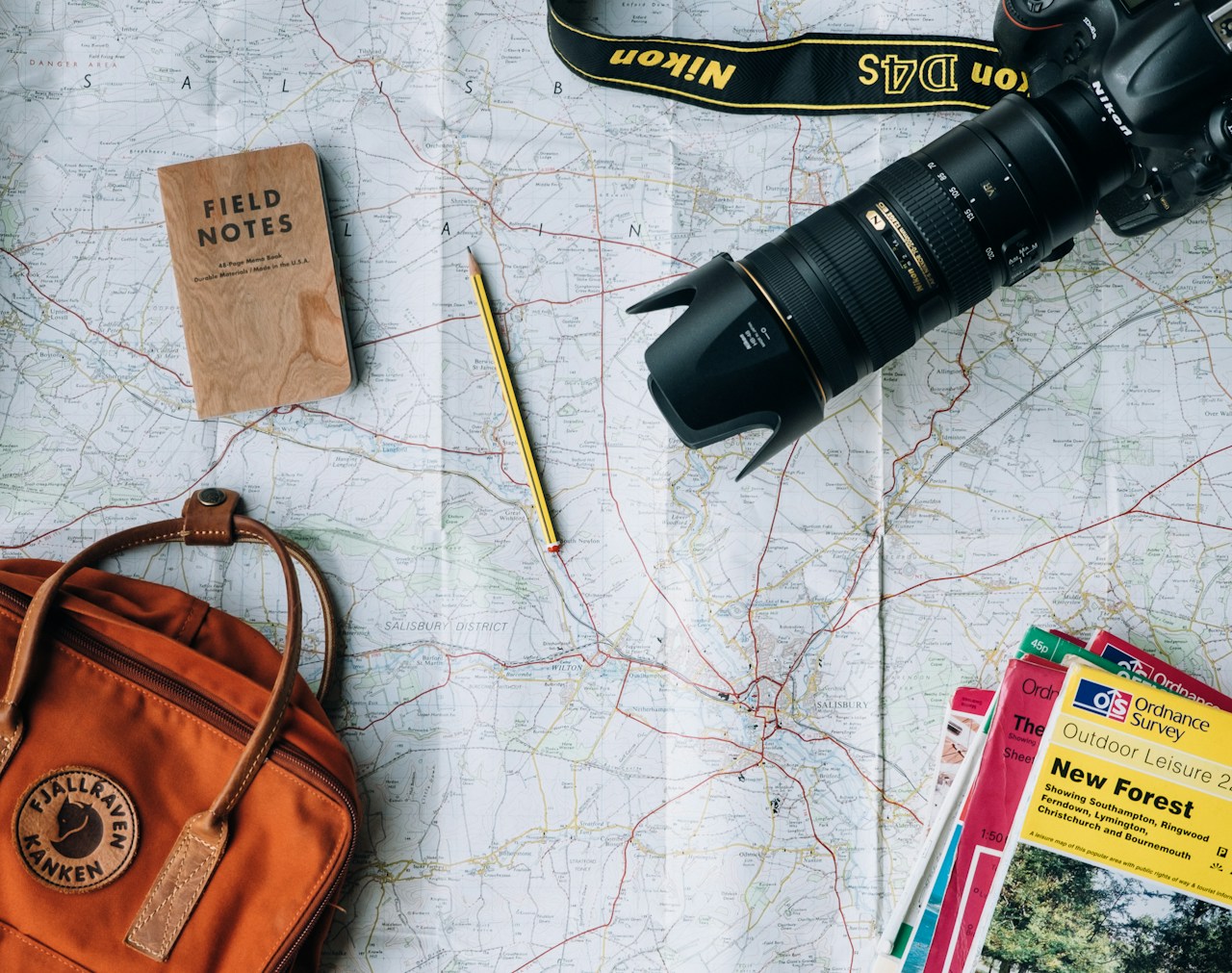 Travel itinerary notebook open with map, pen and coffee — planning a trip format