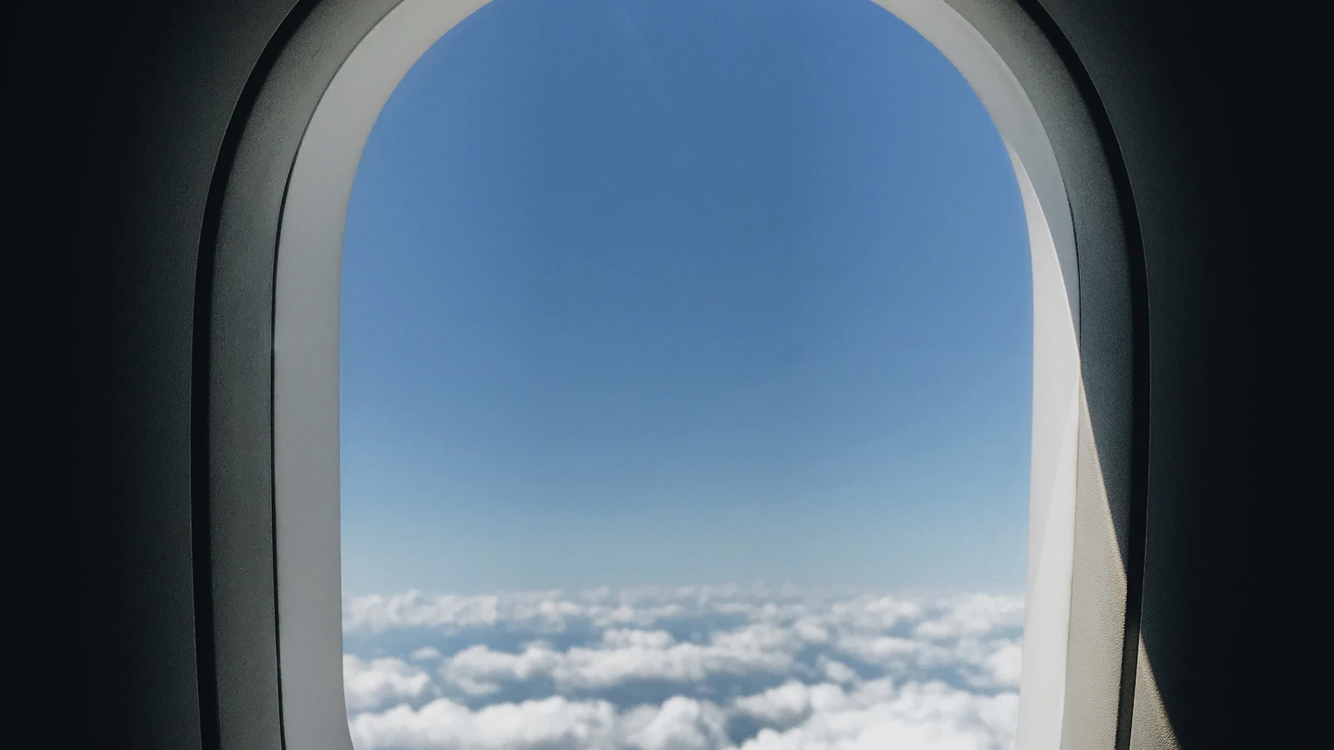 Airplane window view above the clouds on a flight