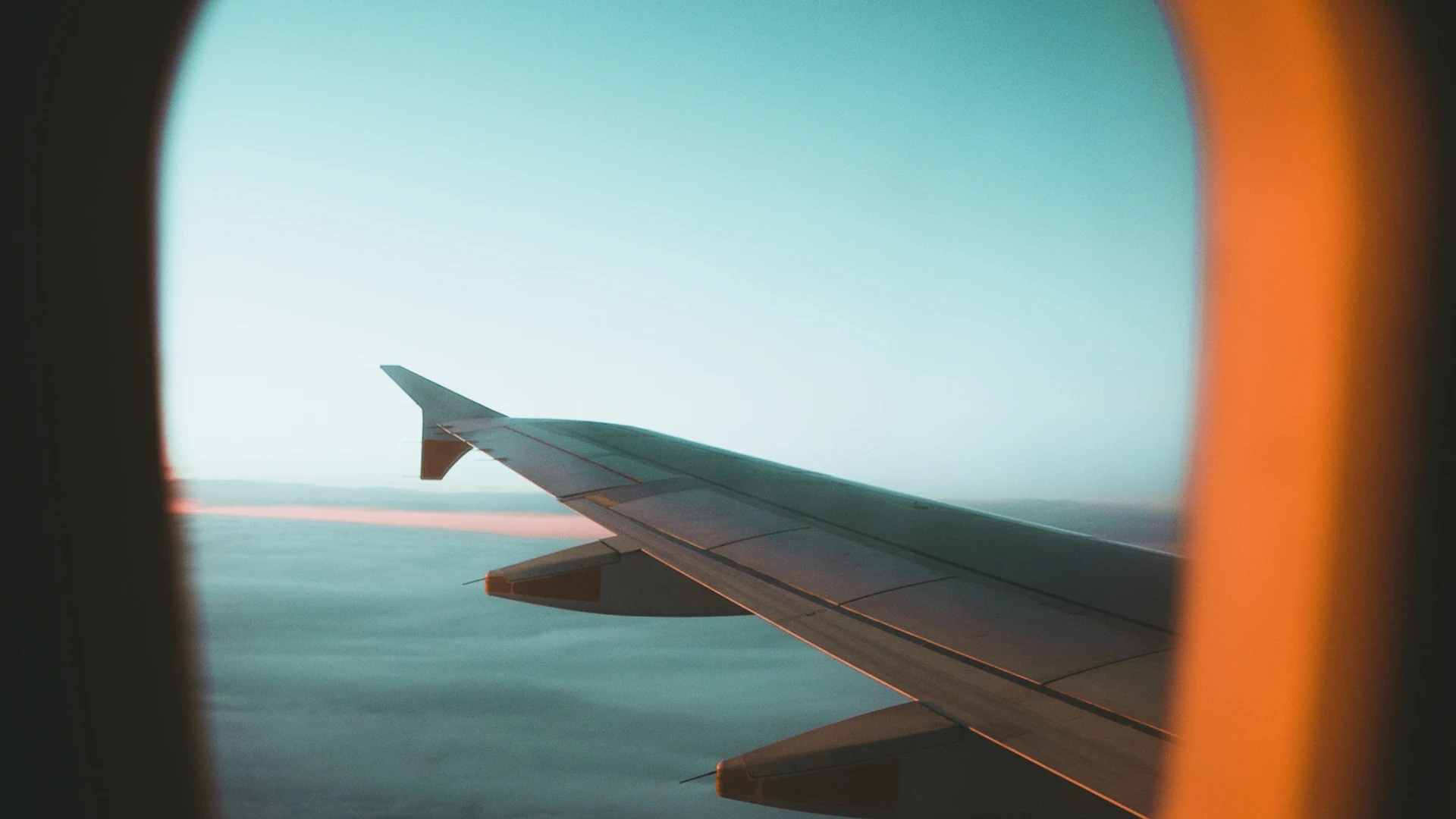 Airplane wing against a sunset sky in flight